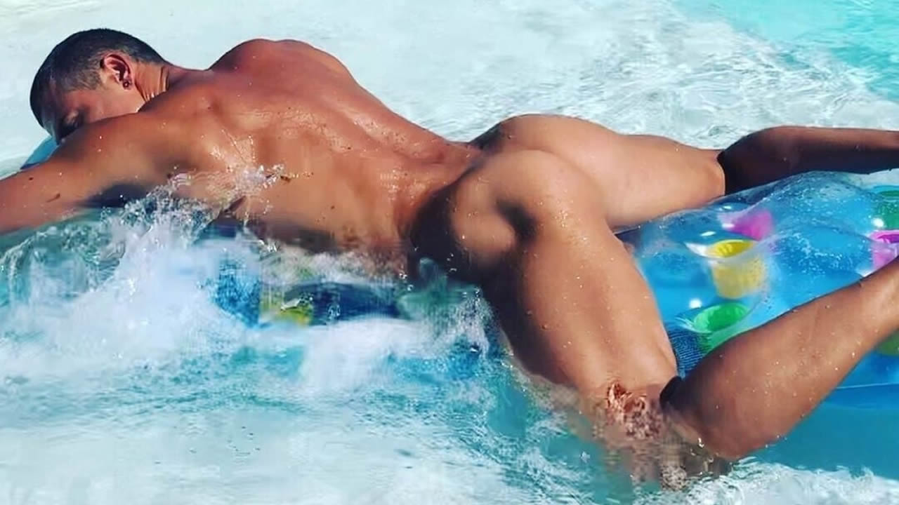 Rearview Naked Hunk Floating in a Pool